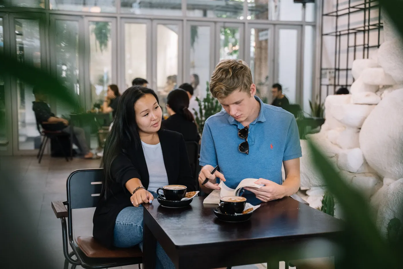 Two friends meeting one-to-one over coffee and a book